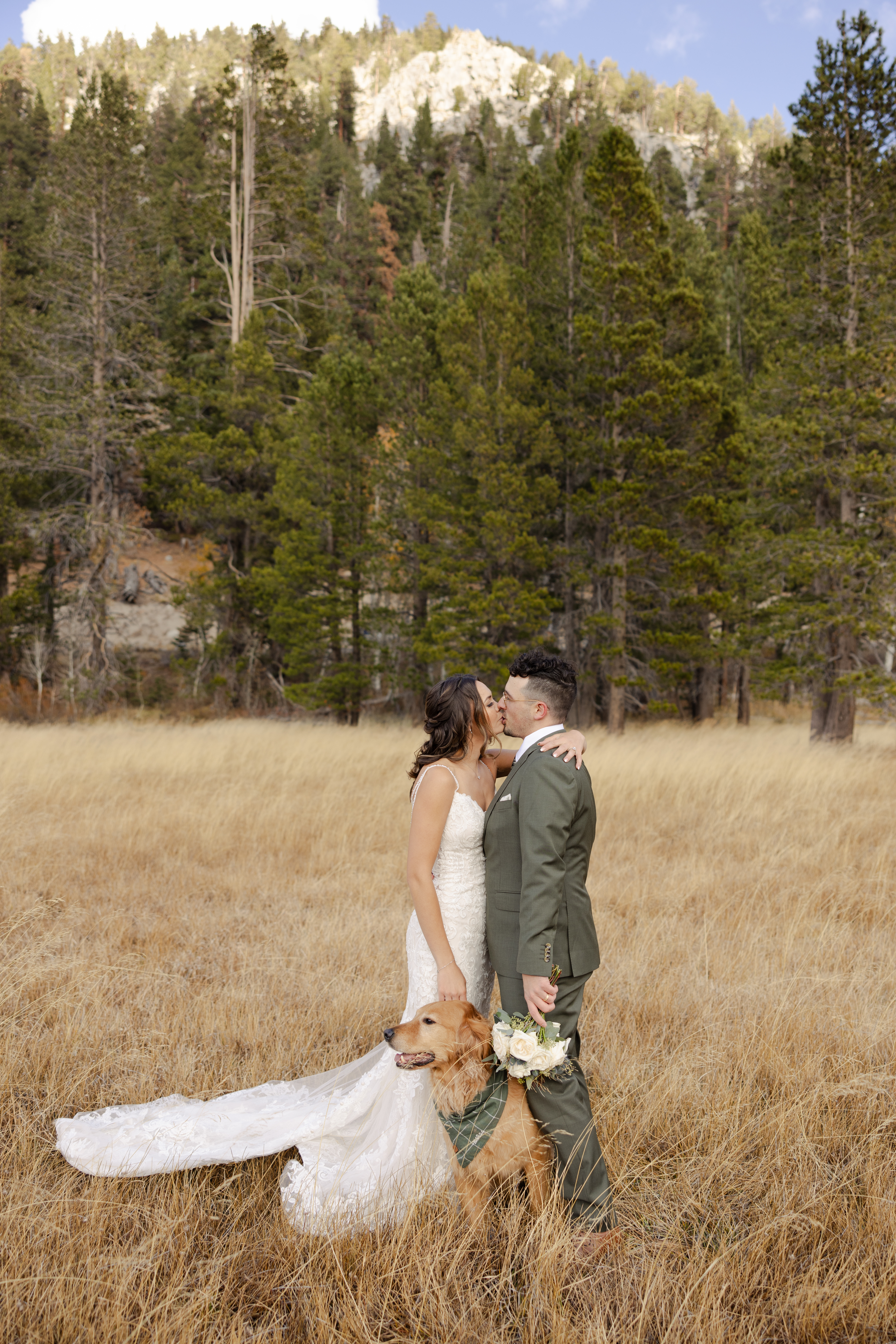 Bride and groom in a beautiful meadow in Lake Tahoe with their dog, capturing a joyful and intimate moment during their elopement in the Sierra Nevada mountains.