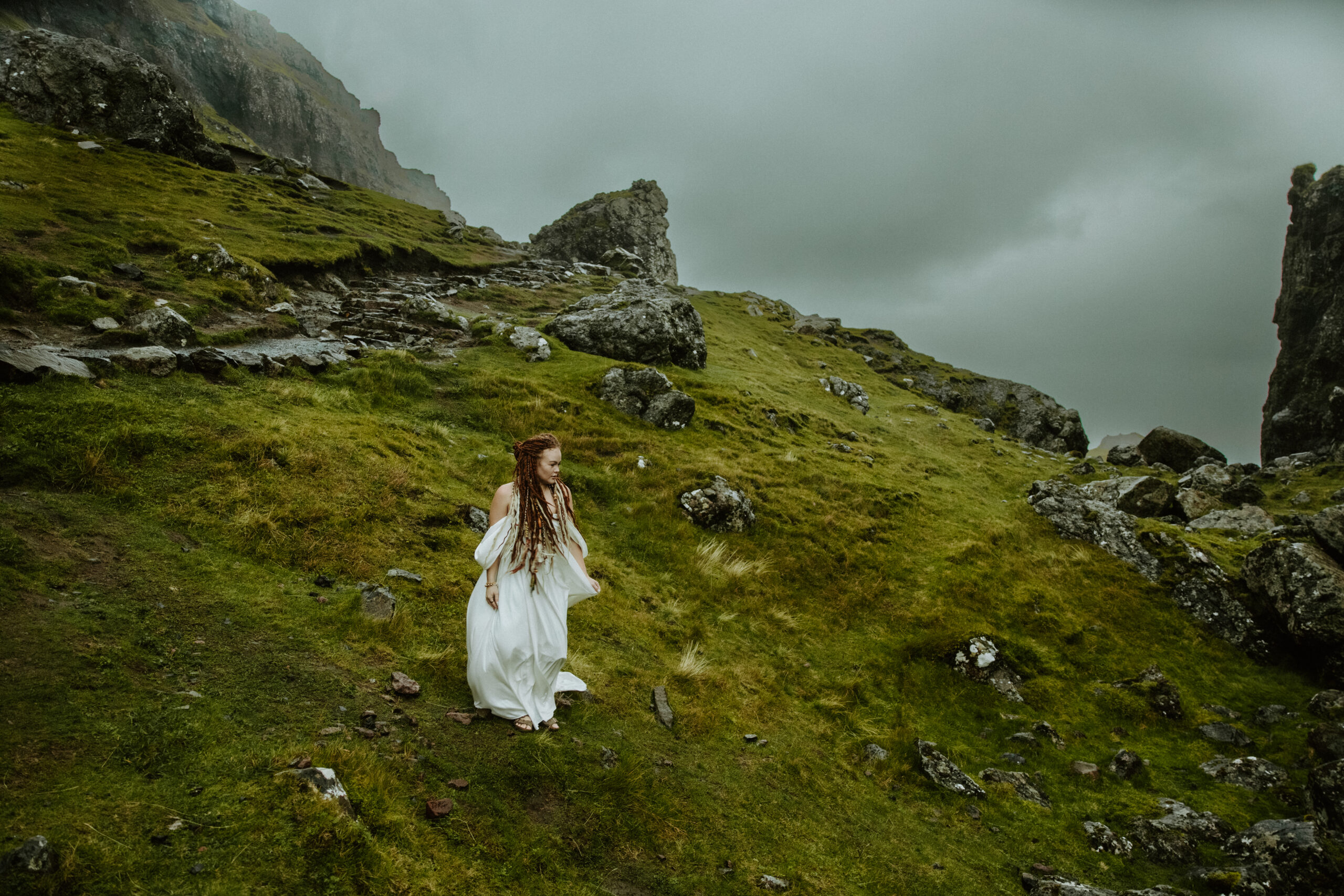 bride standing watching the dramatic clouds come in at the Quiraing.