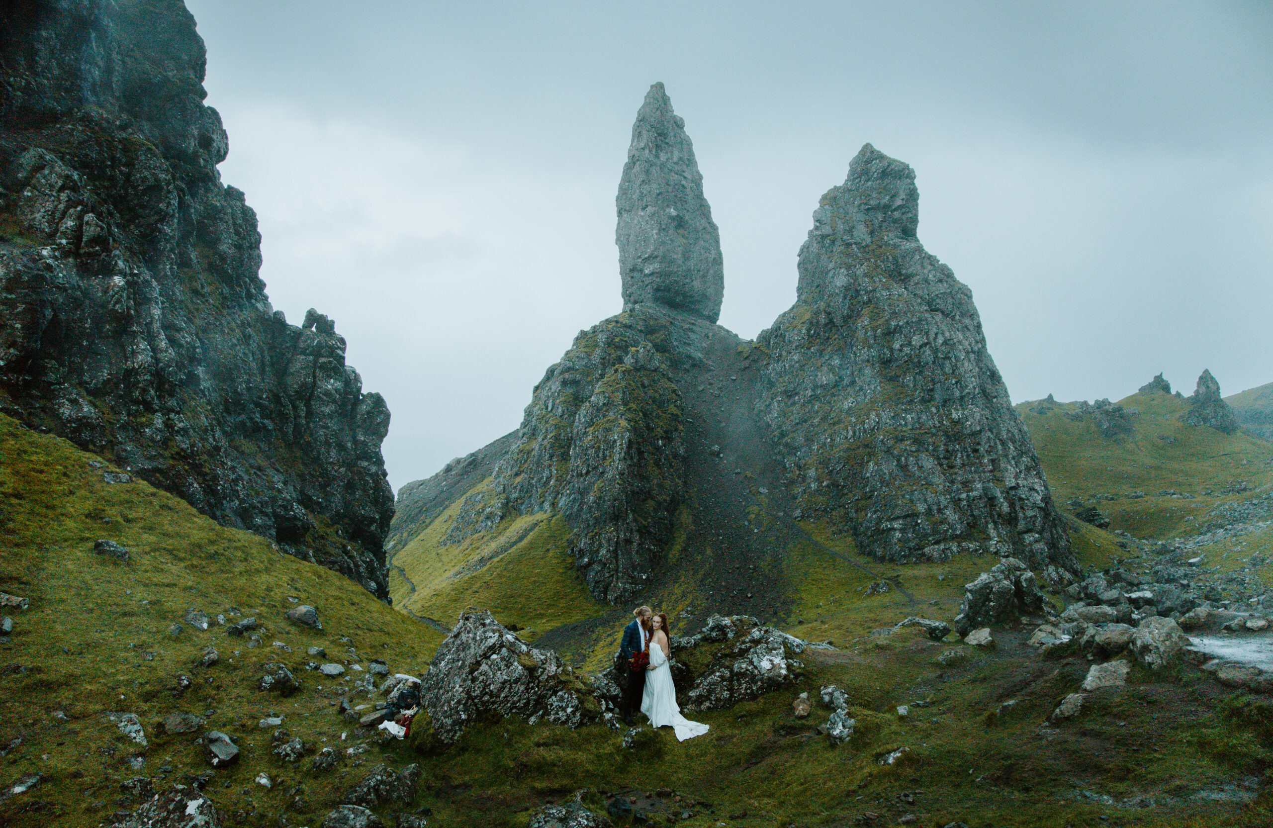 Bride and groom sharing a kiss at sunrise, framed by the iconic pinnacles of the Old Man of Storr on the Isle of Skye.