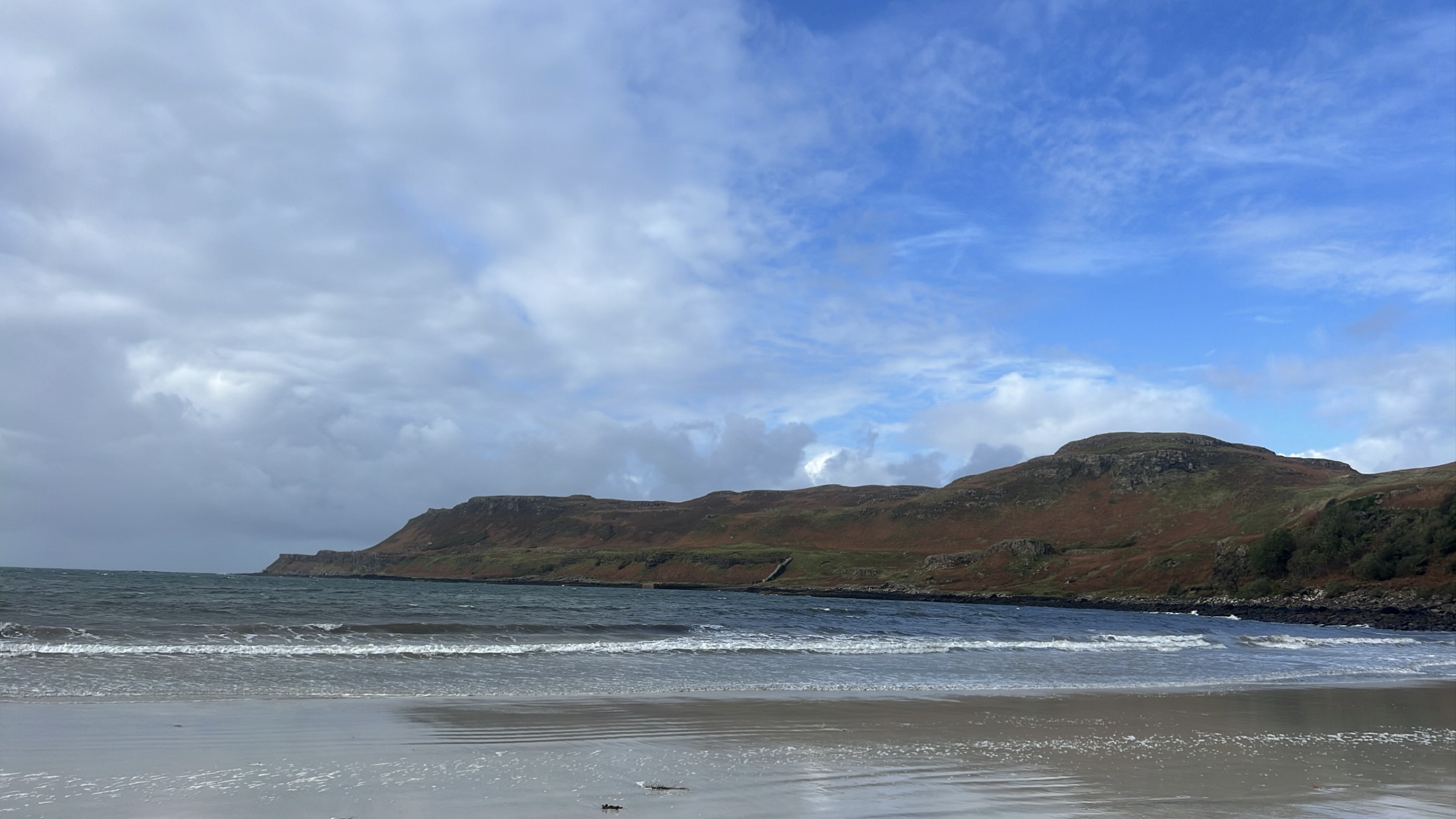 Panoramic view of the Isle of Mull’s rugged coastline, with dramatic cliffs and sparkling blue waters