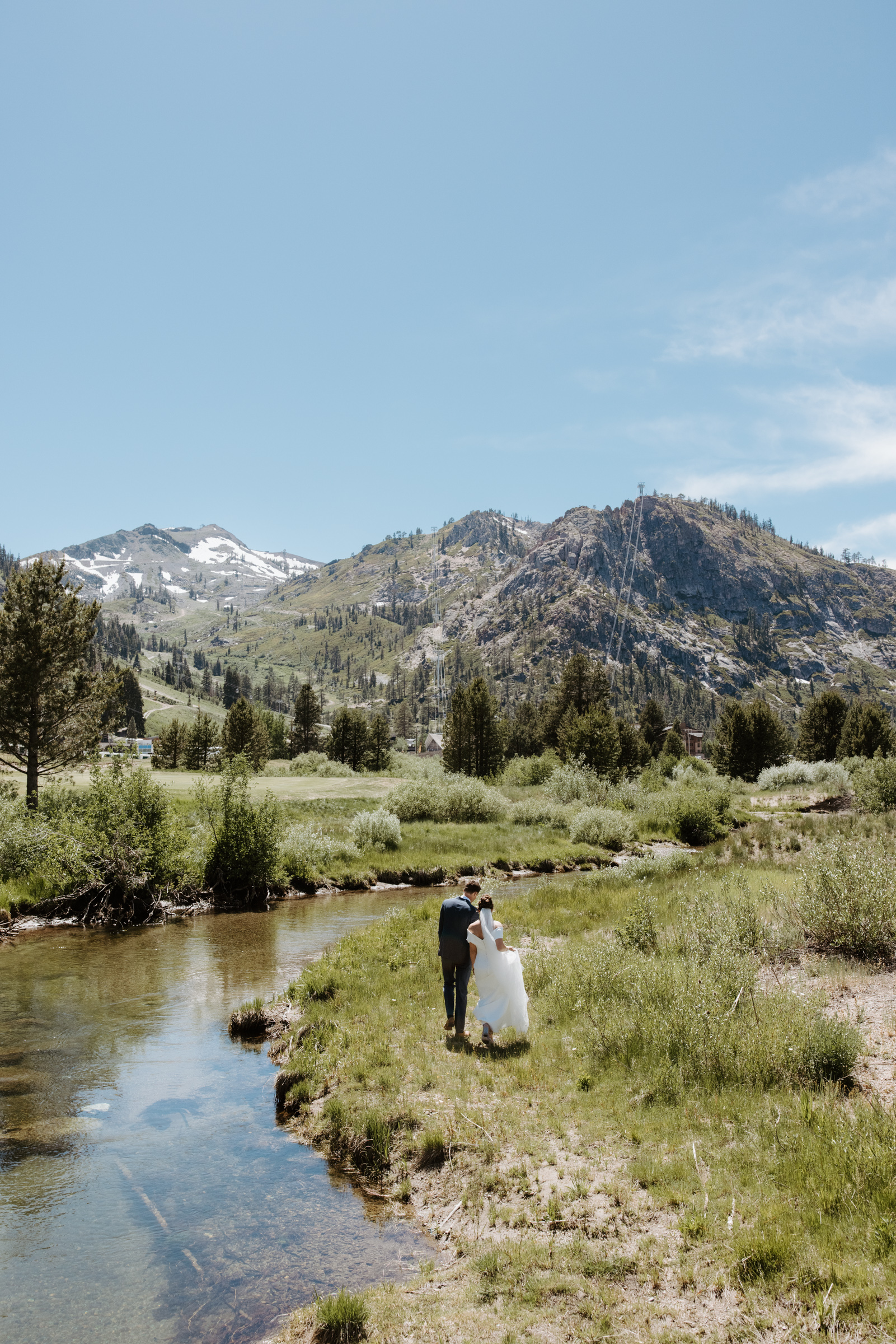 couple walking hand in hand along a river in lake tahoe at wedding