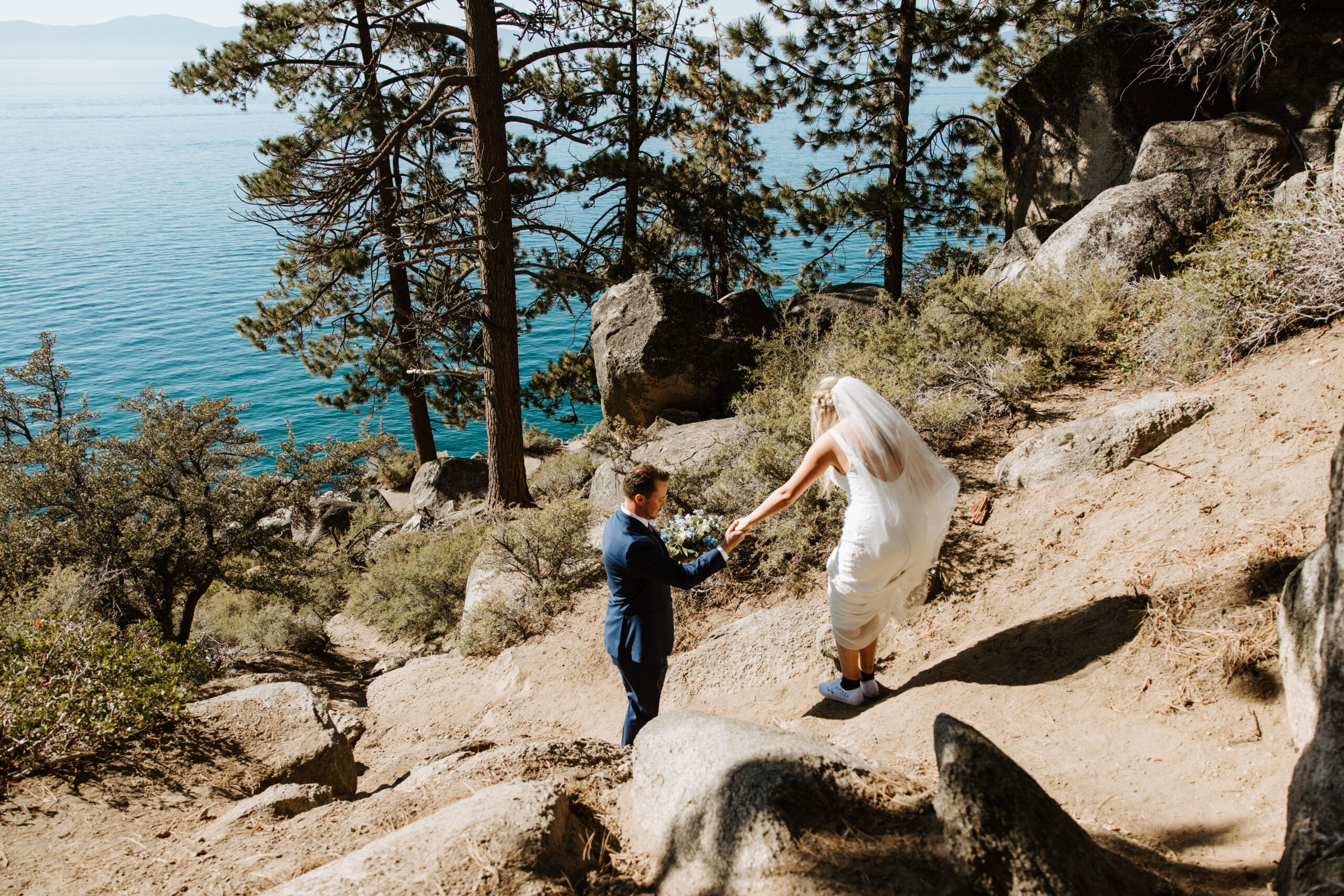 Couple hiking through a forested trail in Lake Tahoe, surrounded by towering pines