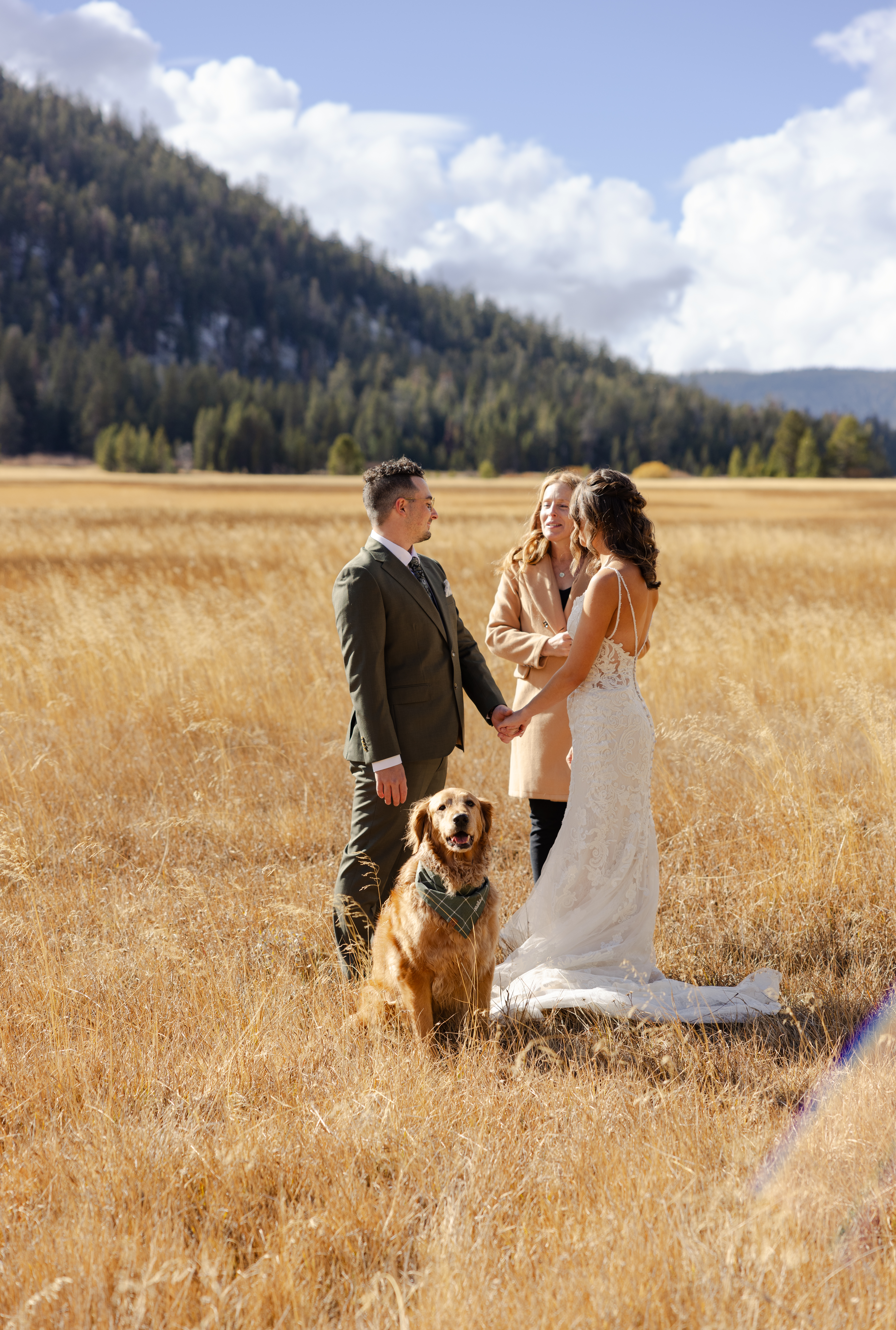 Photo of the couple saying "I do" with their dog sitting in front of them Heartwarming moment as the couple exchanges vows, with their loyal dog sitting proudly in front, making their ceremony even more meaningful and personal.