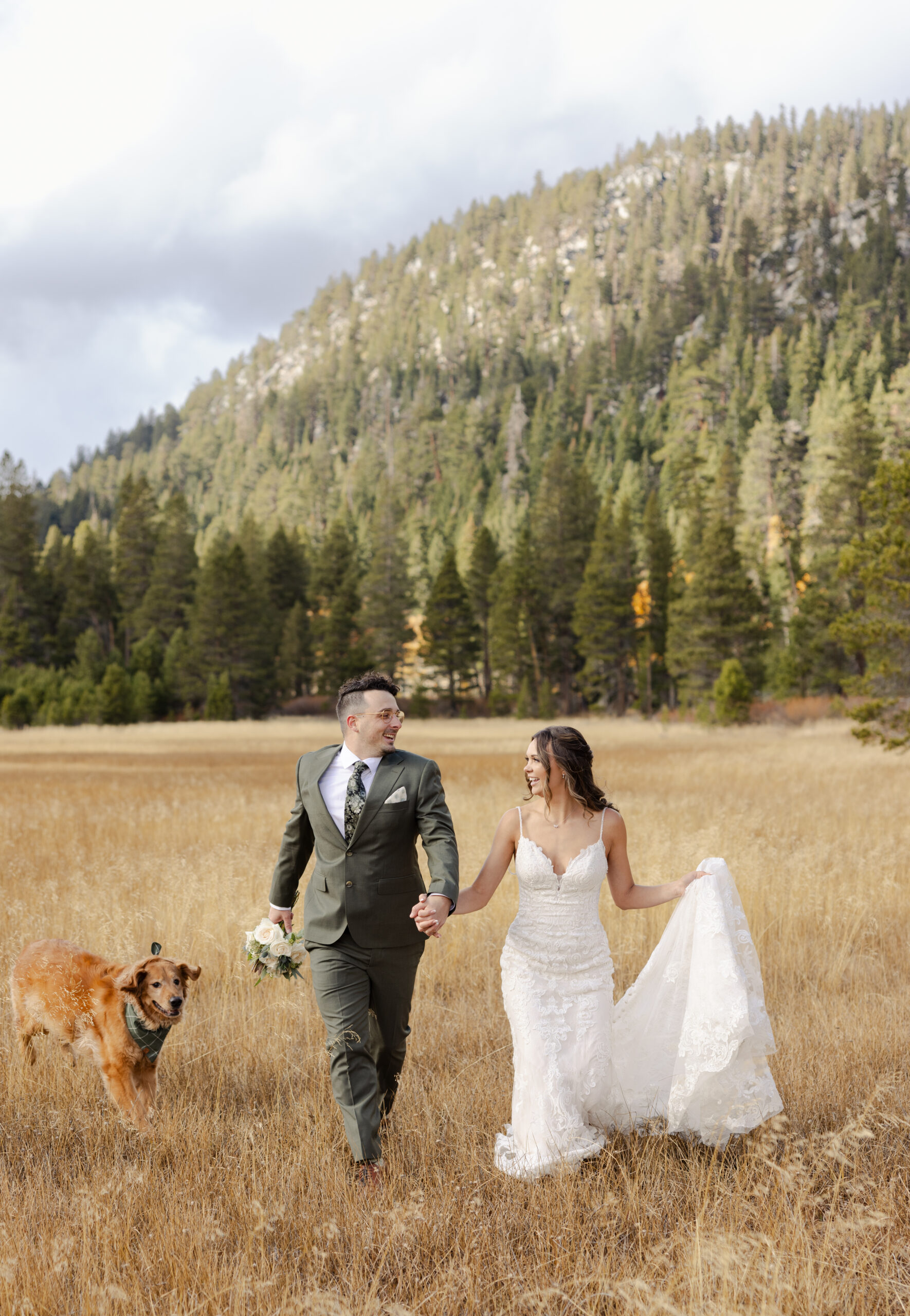 dog running in meadow with couple during an elopement