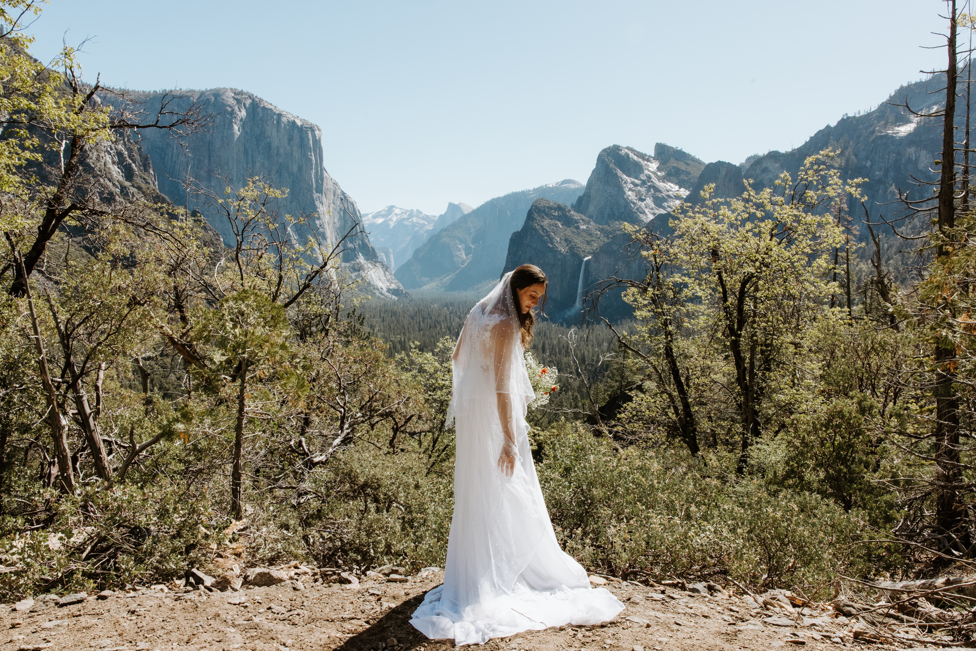 Bride standing at Artist Point, taking in the view of Yosemite Valley below during her elopement.