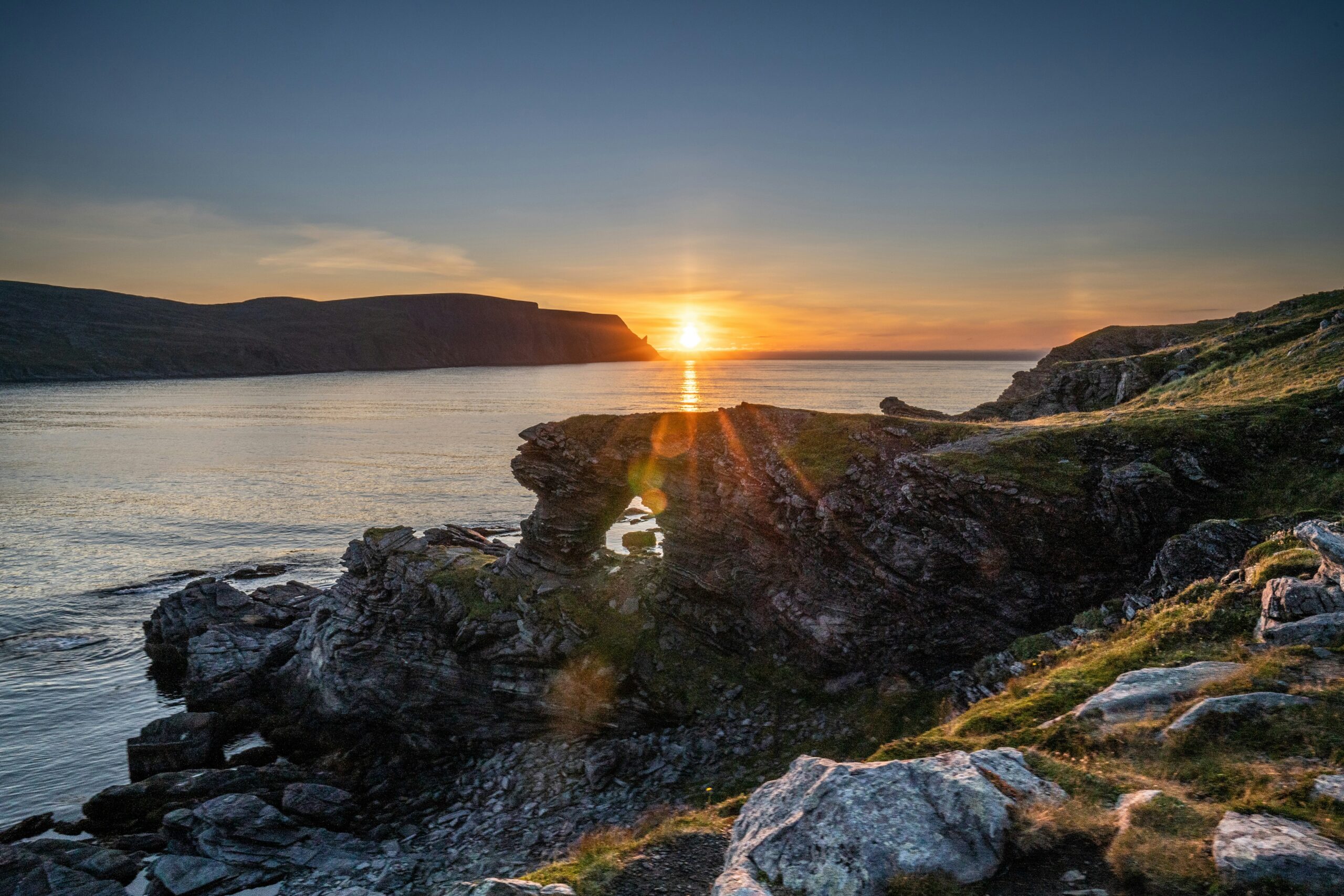 Golden light of the midnight sun over Lofoten fjords and peaks in Norway, perfect for adventurous mountain elopements.