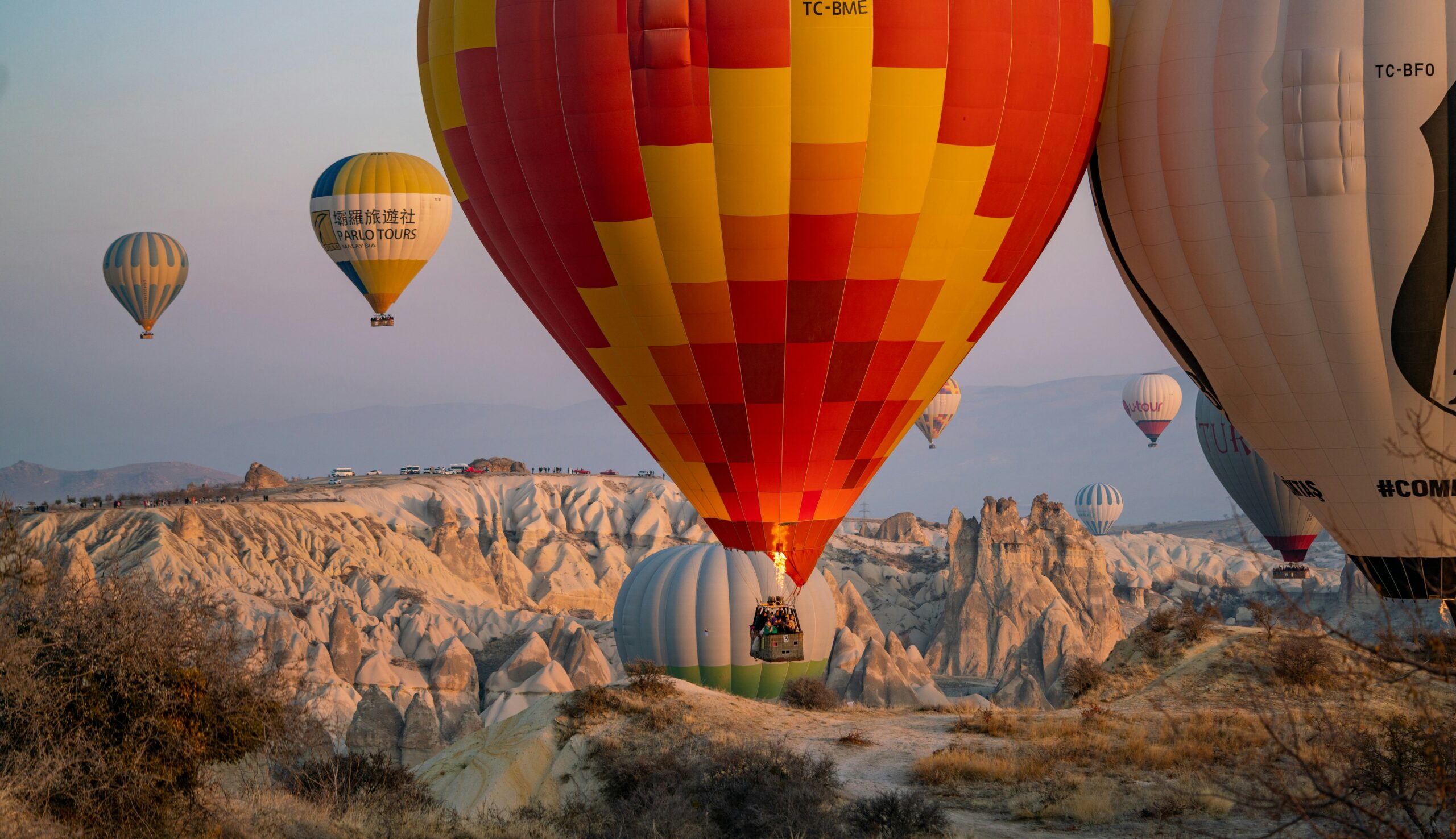 Sunrise hot air balloons over Cappadocia’s fairy chimneys, creating an epic adventure elopement backdrop for couples.